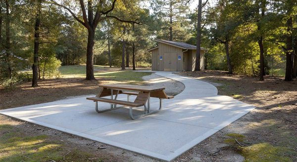 Accessible campsite with paved pad, accessible picnic table, and clear path to restroom