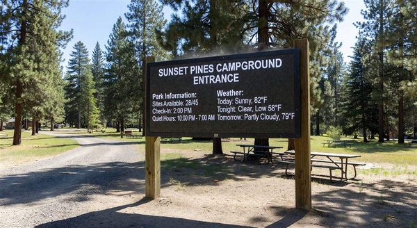 Outdoor digital sign at campground entrance displaying park information and weather