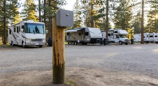 Decibel monitoring sensor mounted on a campground post near RV sites