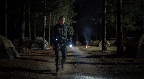 Campground security staff member conducting night patrol with communication equipment