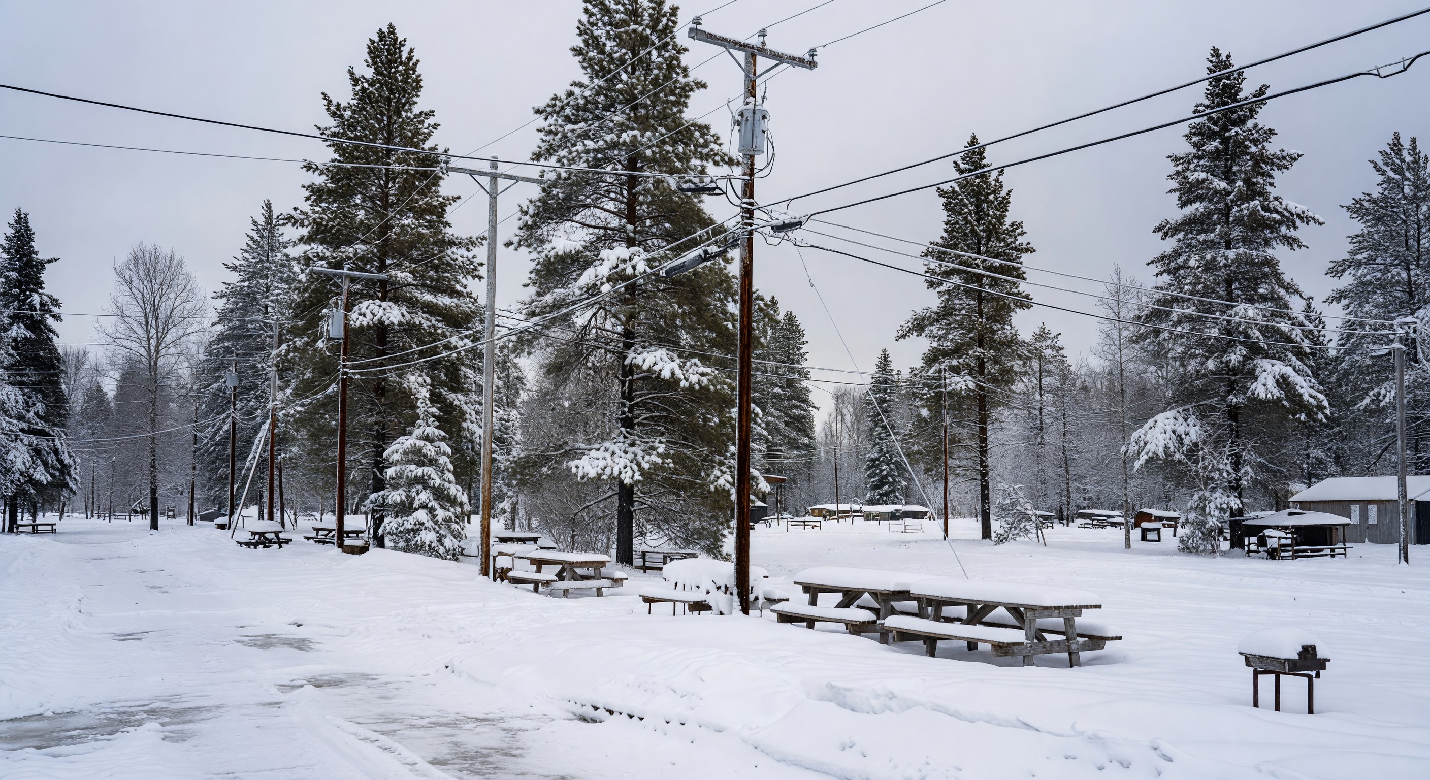 Campground covered in snow with utility infrastructure visible in winter conditions
